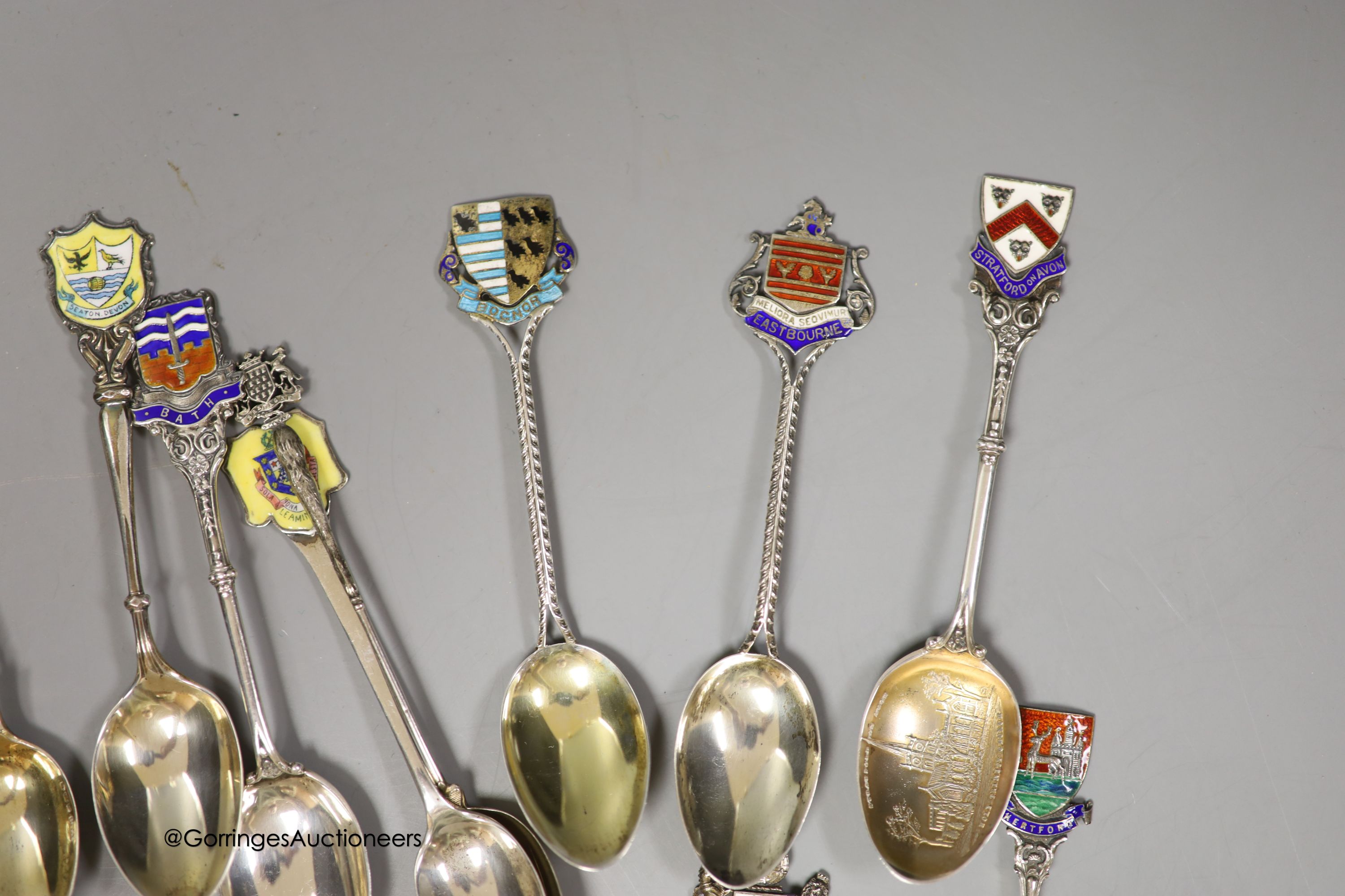 Twenty five assorted 20th century silver and enamel souvenir spoons, including Brighton, Bournemouth, Eastbourne, Chichester etc. and and Edward VII Coronation spoon, together with a similar white metal spoon, gross weig